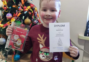 uczeń z dyplomem i nagrodą z konkursu