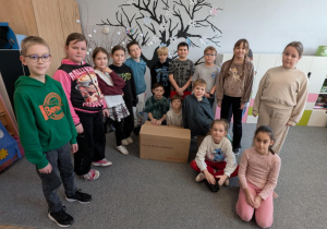 Uczniowie stoją obok pudła z nagrodami