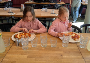 dzieci jedzą pizze