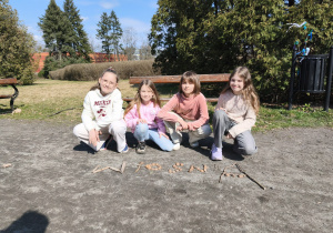 Uczennice pozują przy napisie wiosna.