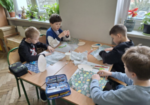 Chłopcy przygotowują serwetki do pracy_