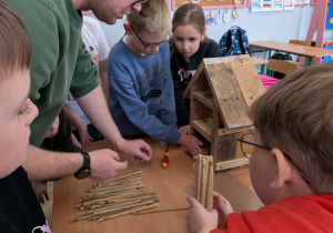 Dzici i męźczyzna budują domek dla pszczół