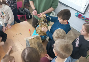 Dzici i męźczyzna budują domek dla pszczół