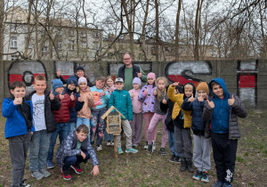 Dzieci stoją przd domkiem dla pszczół. który wykonały