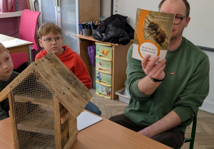 Męźczyzna pokazuje książkę przyrodniczą