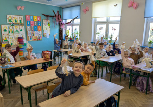 dzieci siedzą w ławkach