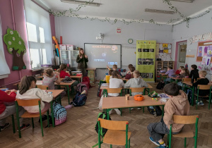 Kobieta opowiada o nietoperzach, a dzieci siedzą w ławkach