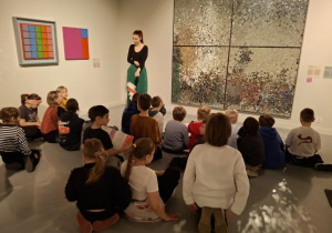 Uczniowie ogladają fotografie na wsytawie w muzeum_