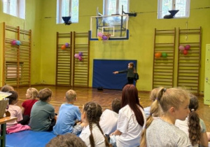uczniowie tańczą na sali gimnastycznej