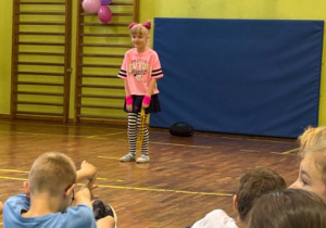 uczniowie tańczą na sali gimnastycznej