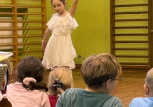uczniowie tańczą na sali gimnastycznej