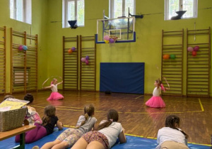 uczniowie tańczą na sali gimnastycznej