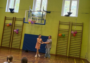 uczniowie tańczą na sali gimnastycznej