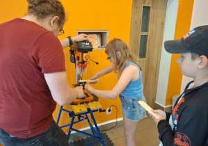 Uczennica wierci elemnty do kolejnego etapu konstrukcji_
