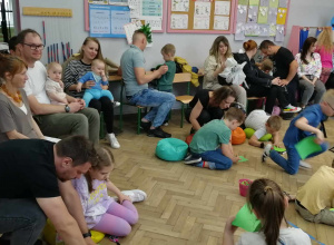 Dorośli i dzieci sedzący