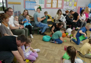 Dorośli i dzieci sedzący