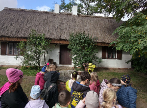 dzieci stoja pod skansenem