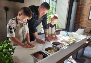 Pierwsi chłopcy szykują pizzę