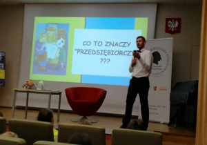Mężczyzna - autor stoi i mówi do mikrofonu