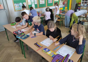 dziesi siedzą przy ławkach